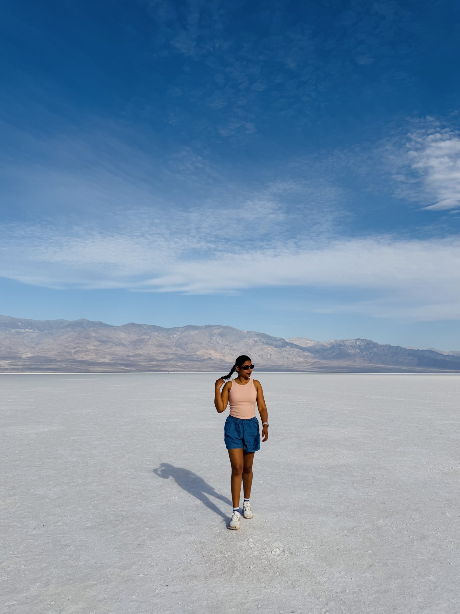 A figure walking on the white salt flats of Badwater Basin