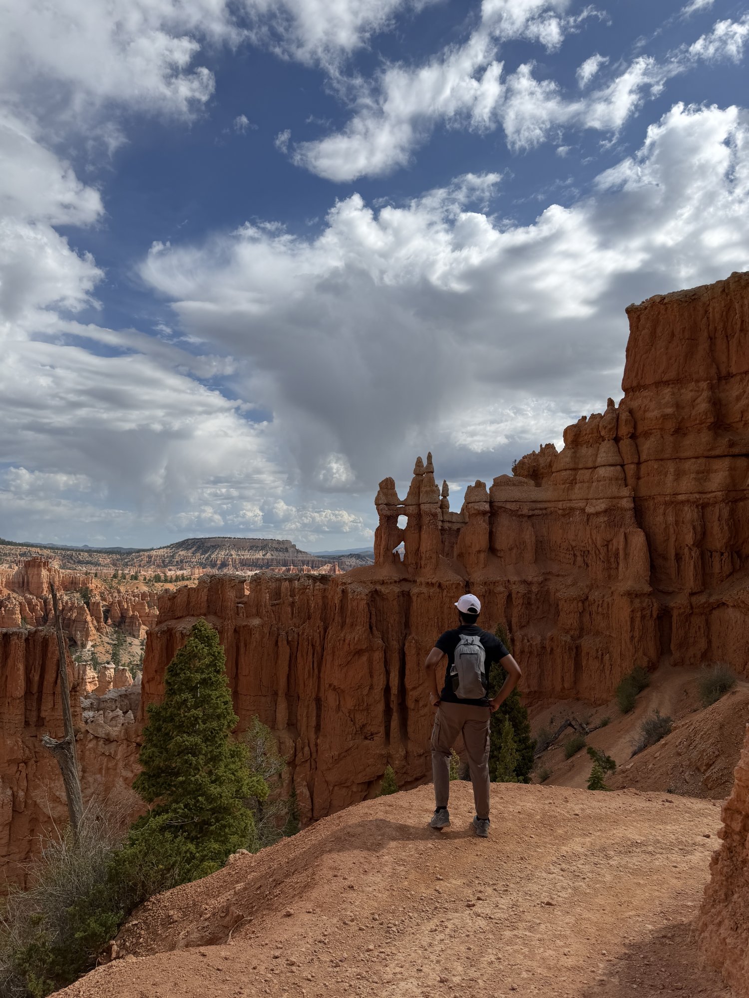 A hiker on a trail among the orange hoodoos of Bryce Canyon