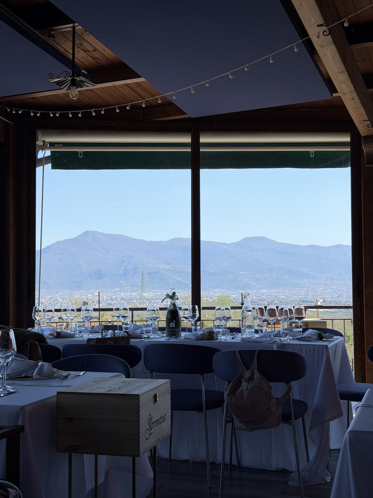 The dining room of the winery with large windows looking out over the bay and mountains, tables set for a big lunch