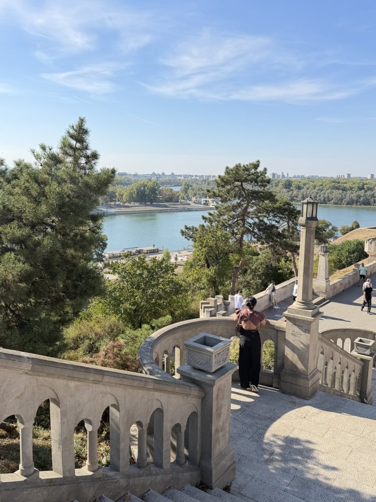 A stone balustrade staircase in Kalemegdan overlooking the river and trees beyond